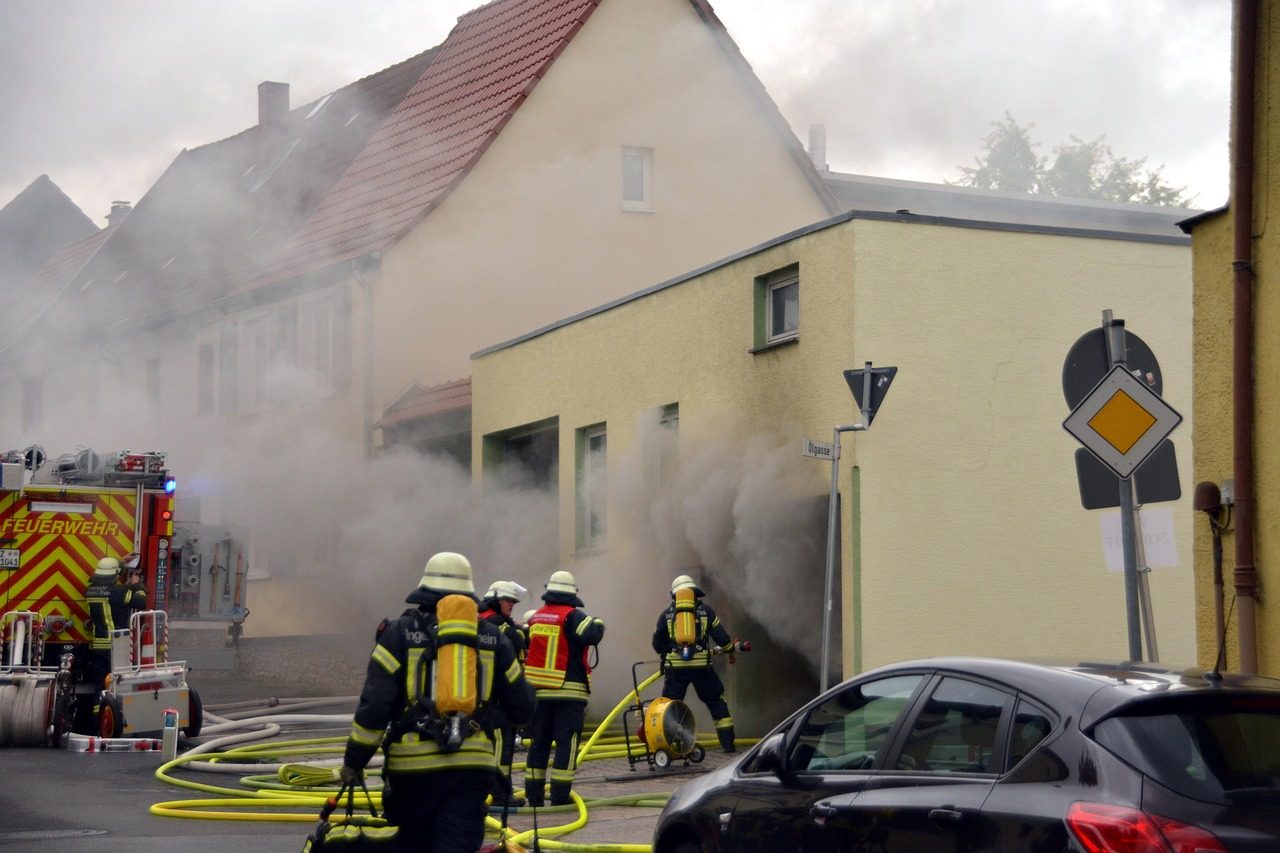 Brandmän vid ett bostadshus där det ryker ur fönstren