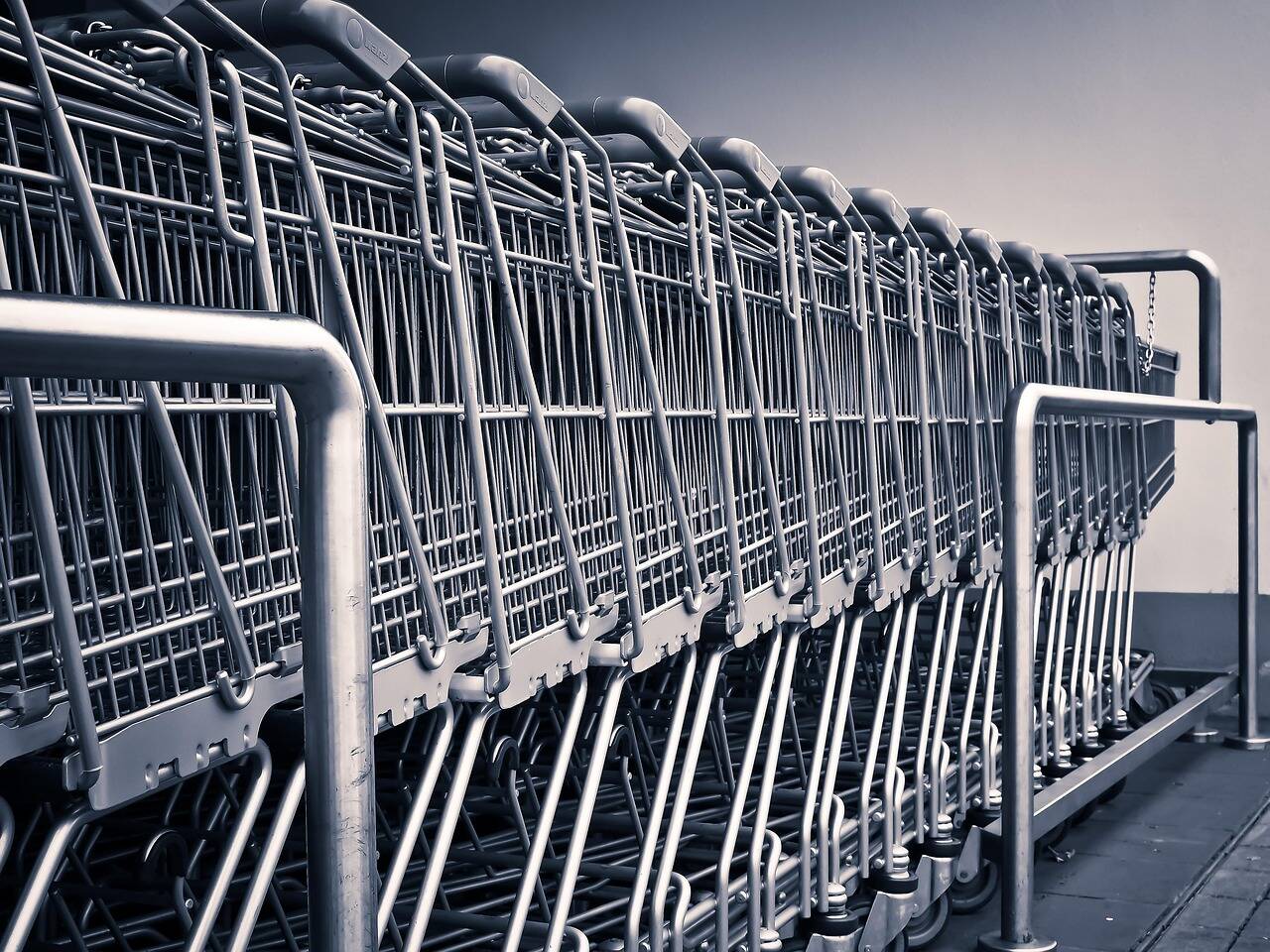 Kundvagnar i stål som står på rad utanför en butik