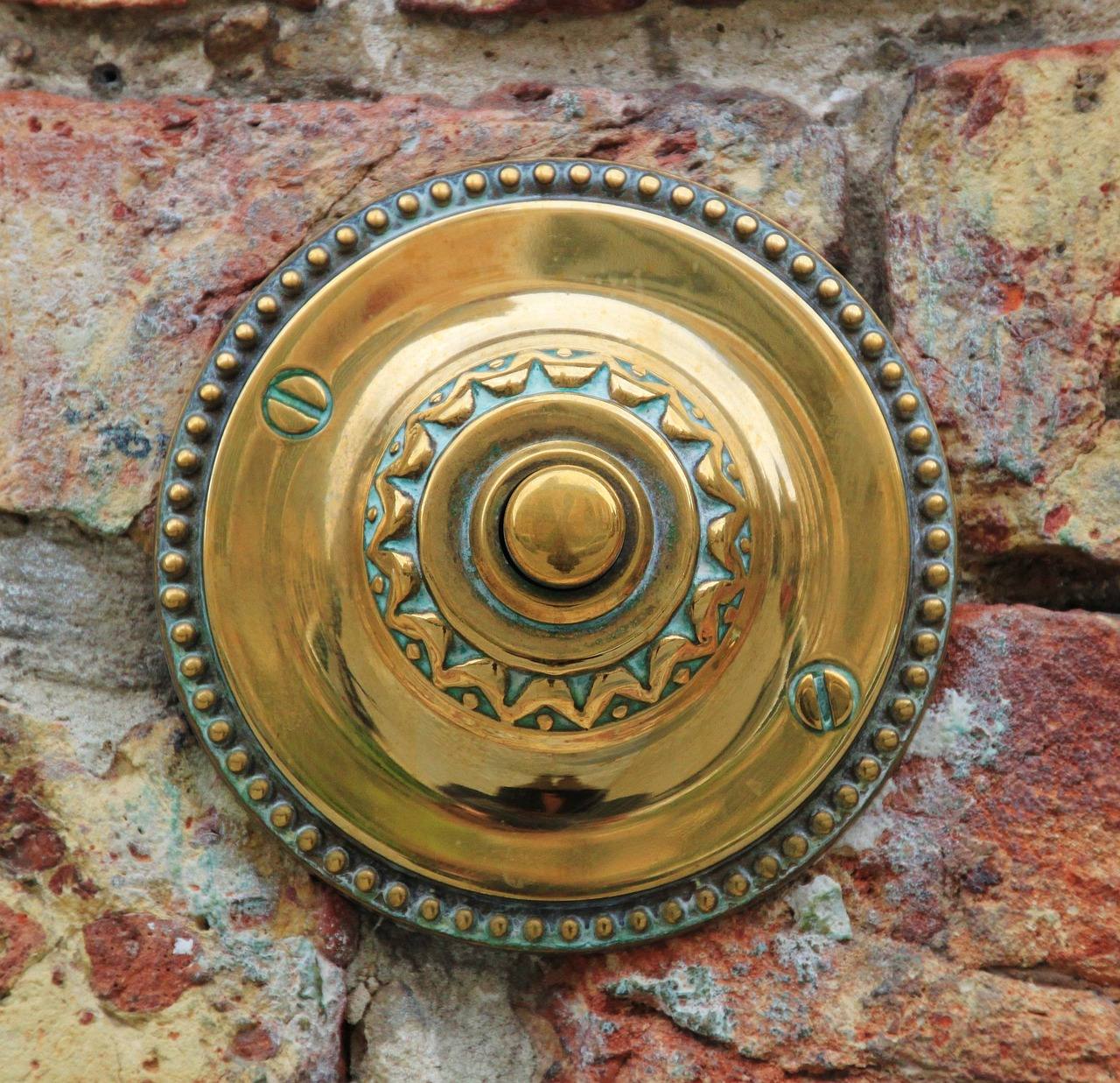 Ringklocka i mässing på en tegelvägg