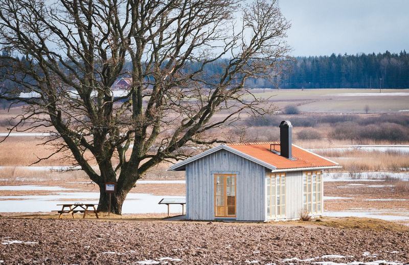 Liten stuga vid en åkerkant en vinterdag